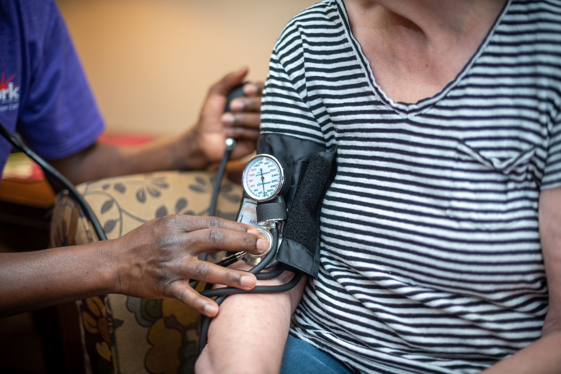 Nurse checking blood pressure on senior man’s arm - memory care centers