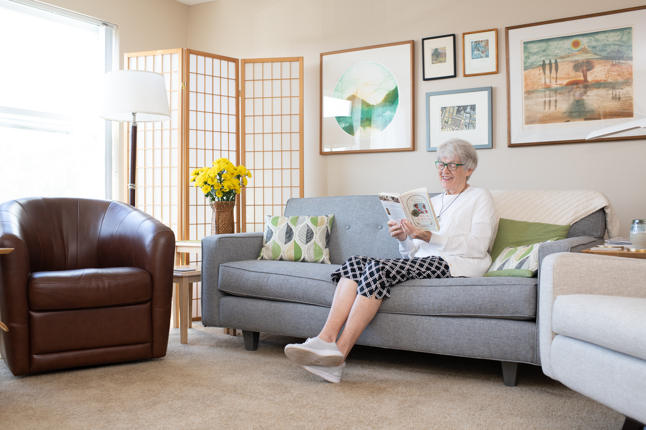Senior relaxing in a well-lit assisted living lounge with sofas - elderly facilities near me