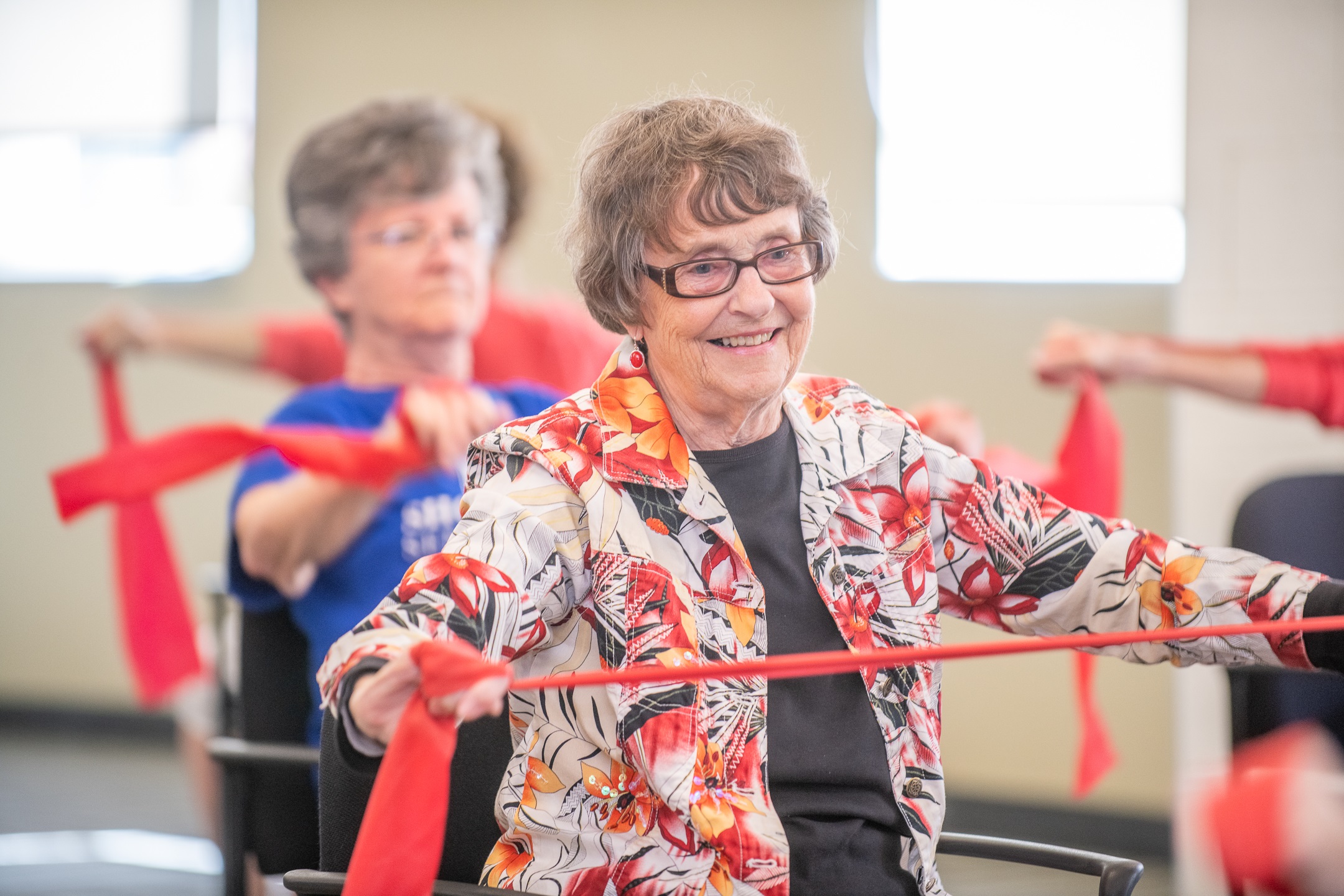 Elderly woman enjoying a painting activity in a group setting - long term care facilities near me