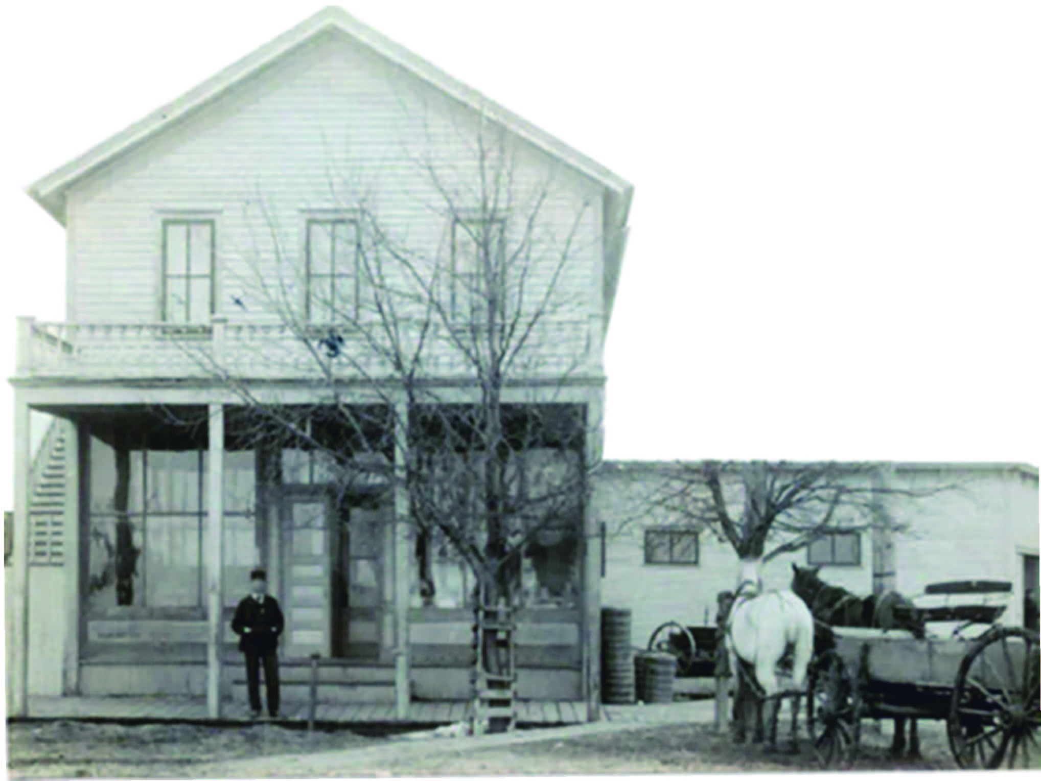 Vintage photo of an old farmhouse with family standing out front - retirement communities
